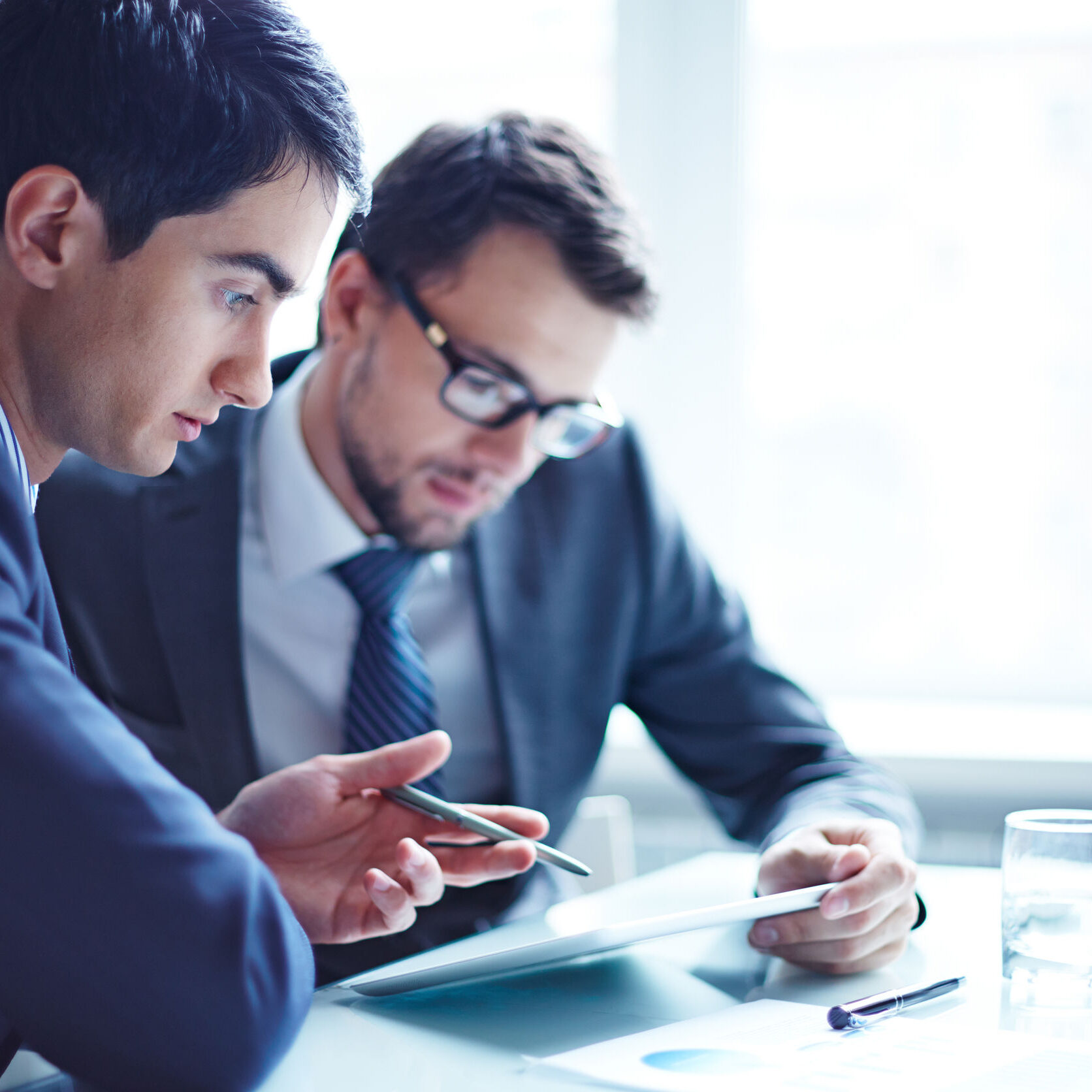 Serious businessman explaining data to his colleague at meeting