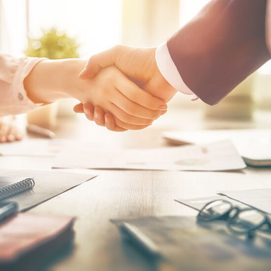 Man and woman are shaking hands in office. Collaborative teamwork.